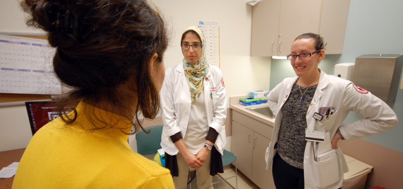 Medical students Noha Eshera (left) and Sophia Ciaravino discuss a patient’s health concerns at the TEACH and CARE clinic.