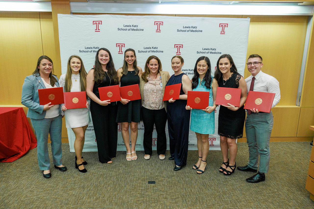 A group of 2023 award recipients from the Lewis Katz School of Medicine and a faculty member posing for a photo and holding awards 