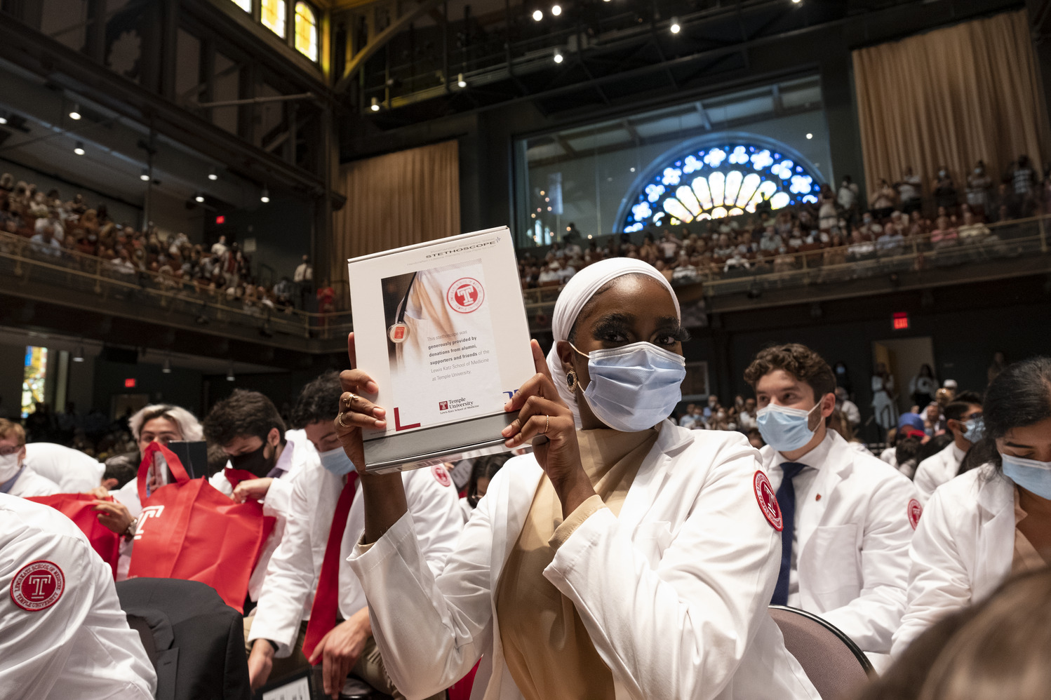 Student holding the first gift of a Temple-branded stethoscope