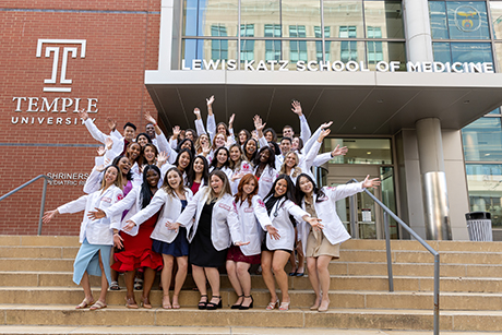 Physician Assistant students doing a celebratory pose in front of the Lewis Katz School of Medicine