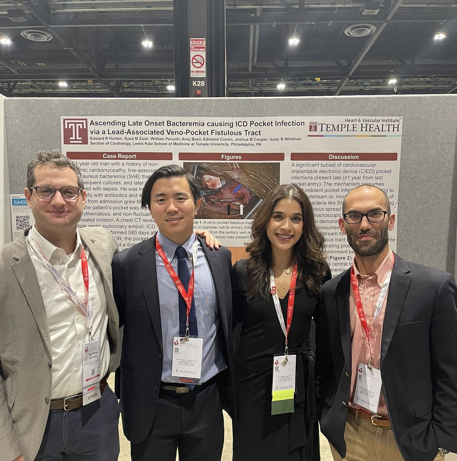 Four cardiology fellows standing in front of the Temple booth