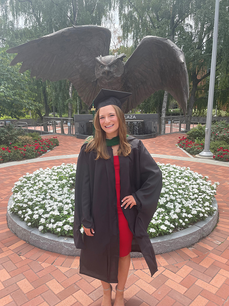 Alexa Burychka in her graduation cap in front of the Temple owl statue