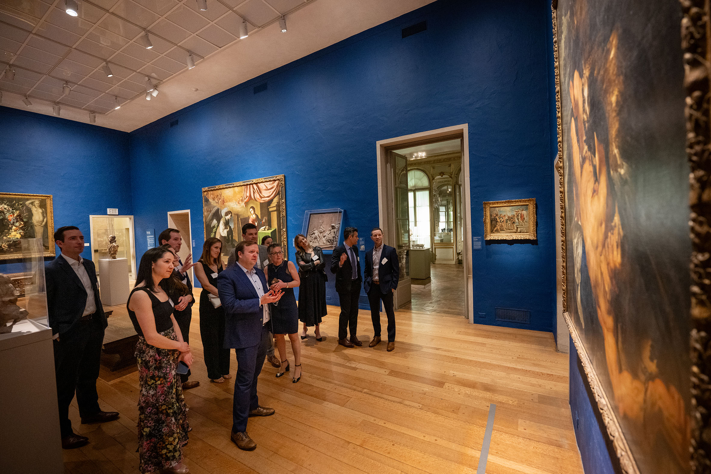 Group of people looking at art paintings on the walls