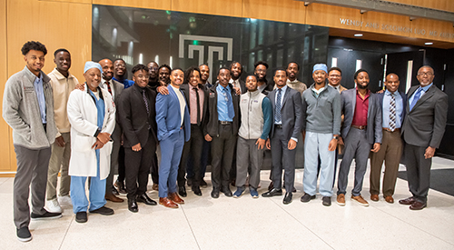 black men and doctors in front of the Temple T logo