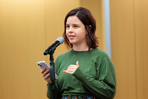 a woman reading her story from her phone at the Story Slam