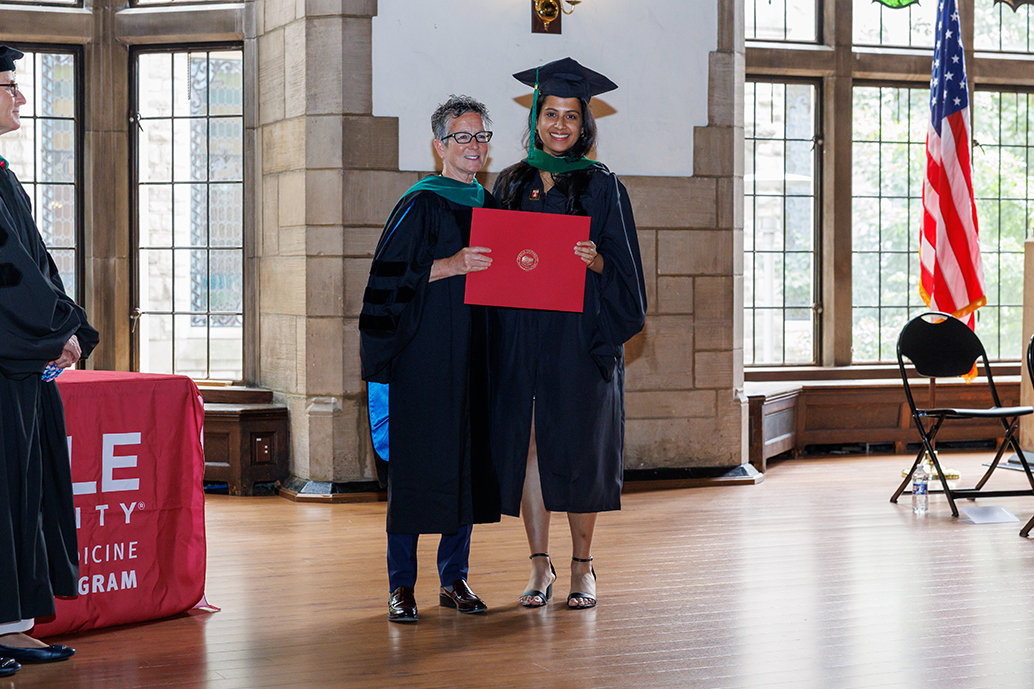 Interim Dean Amy Goldberg MD, FACS handing out a diploma to a Physician Assistant graduate