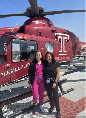Kaitlyn McSurdy and Tashawni M. Channer stand in front of the Temple medevac helicopter