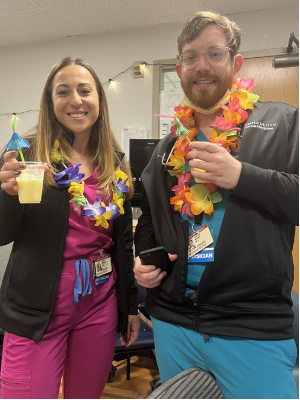 Kaitlyn McSurdy and Andrew Motzer dressed in scrubs enjoying a luau-themed event