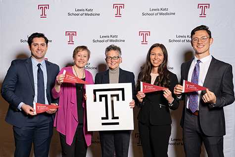 Dr. Amy Goldberg and two women and two men pose with the Temple T and pendants