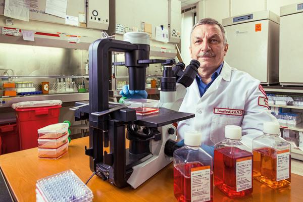 Tomasz Skorski, MD, PhD, DSci, with a microscope in a lab