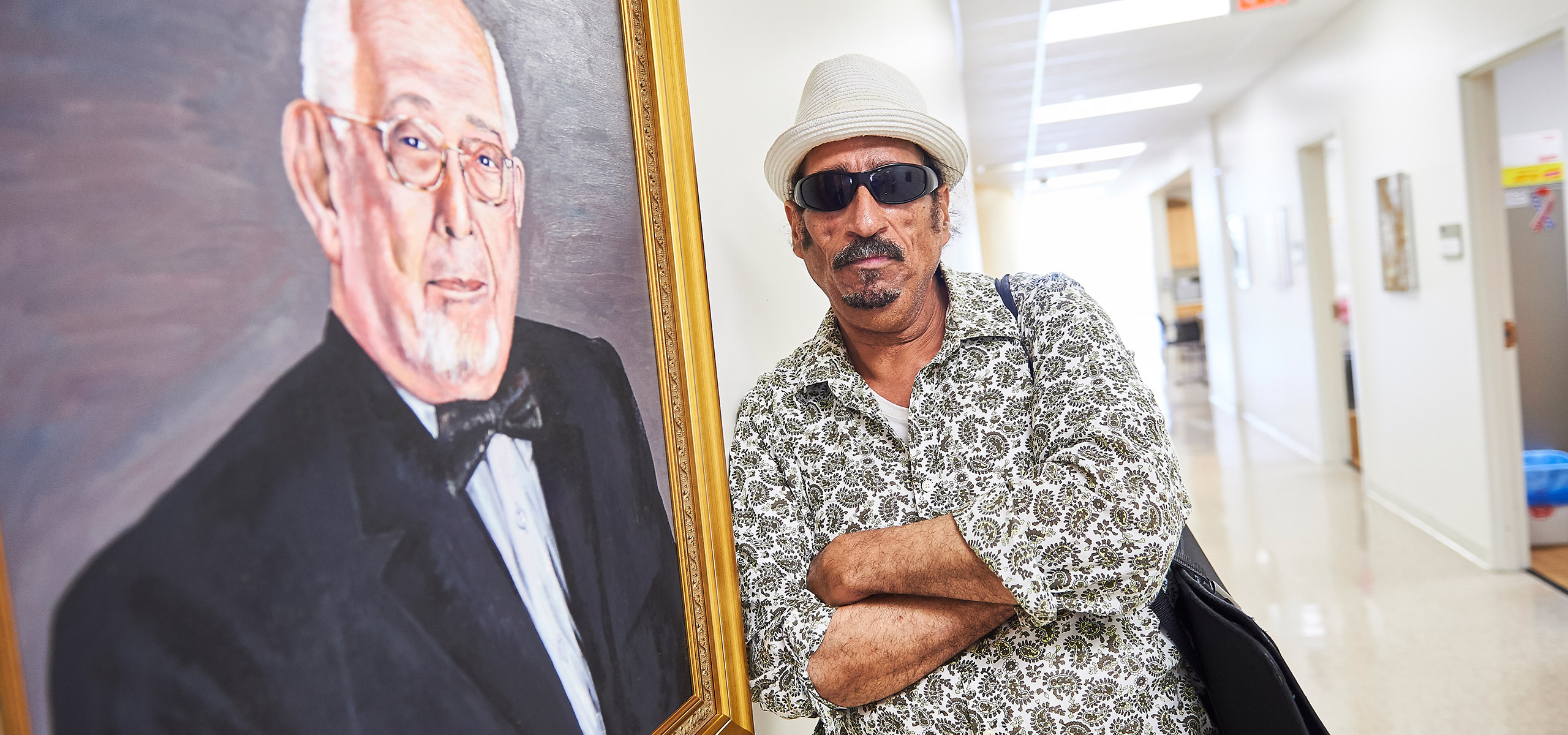 Jonathan Thomas with his portrait of Dr. Leon Salganicoff on the 9th Floor of the Medical Education and Research Building. Photo Credit: Ed Cunicelli