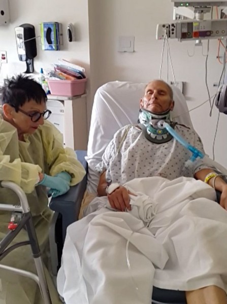 Aaron Levine, injured in the crash of Amtrak train 188, lays in a bed, attached to a breathing machine, in the ninth floor surgical intensive care unit at Temple University Hospital. His wife, Barbara, who fractured her pelvis in the May 12, 2015 derailment, is at his side. 