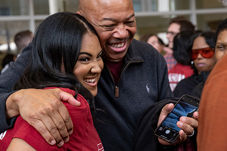 an older man embracing a female medical student in excitement