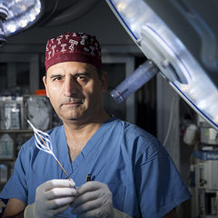 Riyaz Bashir, MD, FACC, in an operating room, holding an endovascular catheter