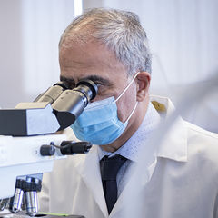 Dr. Khalili looking into a microscope