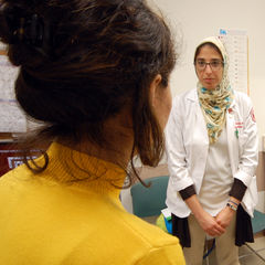 Medical students Noha Eshera (left) and Sophia Ciaravino discuss a patient’s health concerns at the TEACH and CARE clinic.
