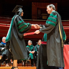 Larry Kaiser shaking a graduates hand