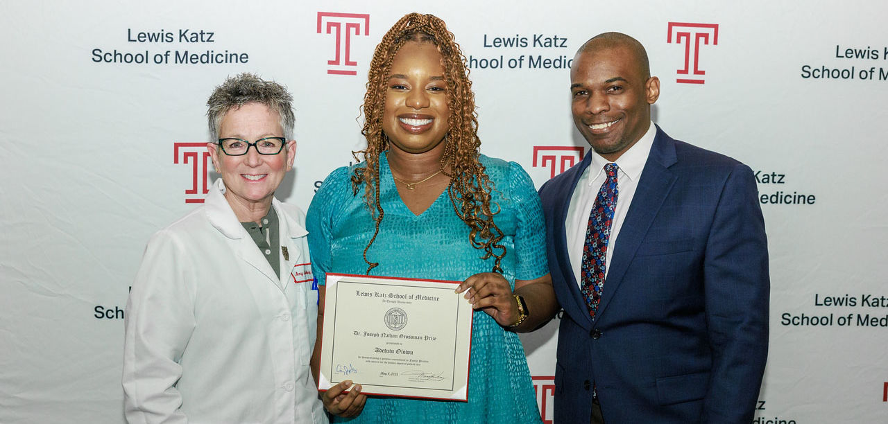 Award recipient Adetutu Olowu holding her award, with Dr. Amy Goldberg and another person 
