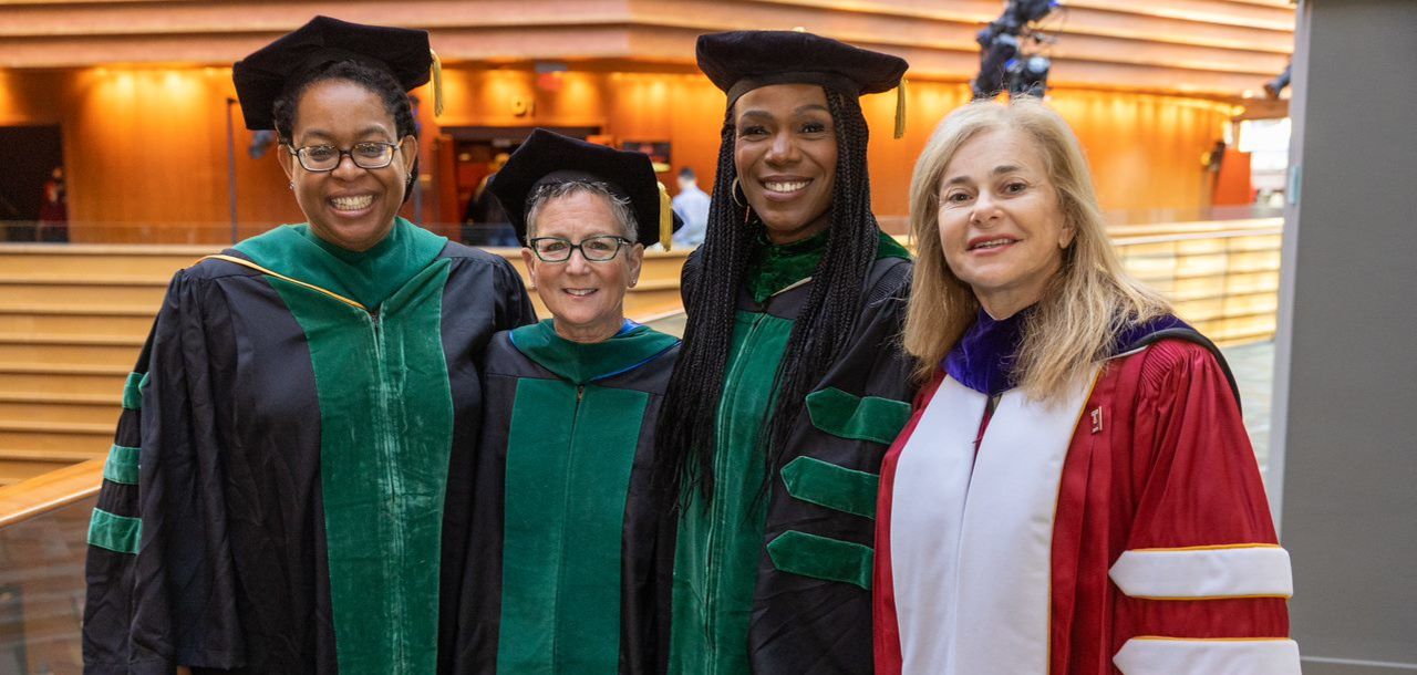 Dr. Amy Goldberg, Dr. Ala Stanford, and two other women wearing graduation gowns